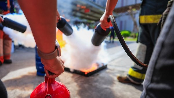 Feuerwehr Brandschutz Feuerlöscher Personen in Schutzkleidung löschen ein Übungsfeuer.
